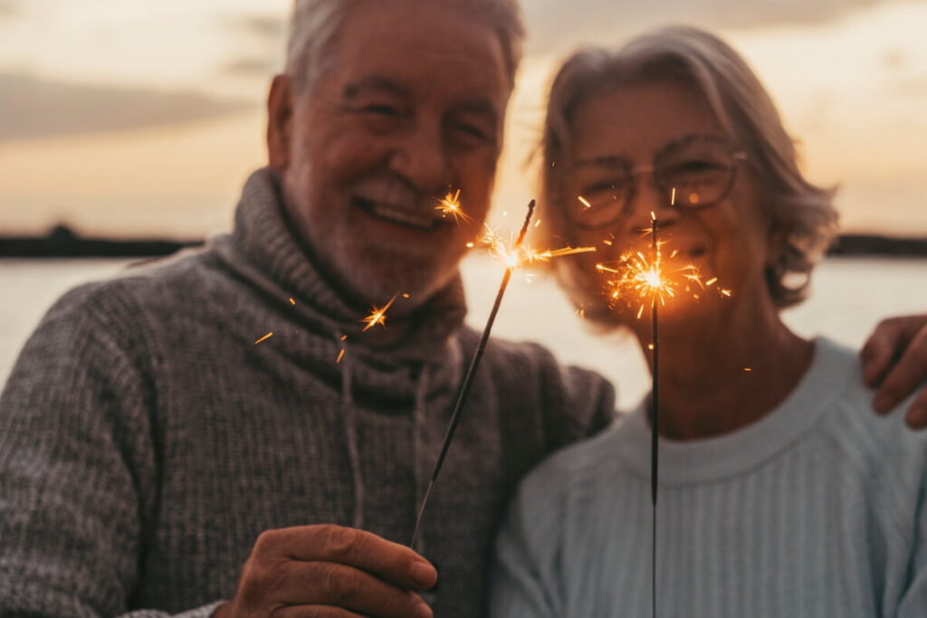 Older adults holding sparklers.