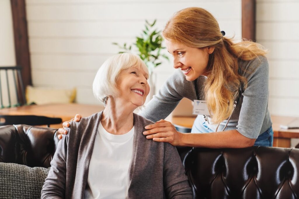 Caregiver and senior woman looking at each other and smiling