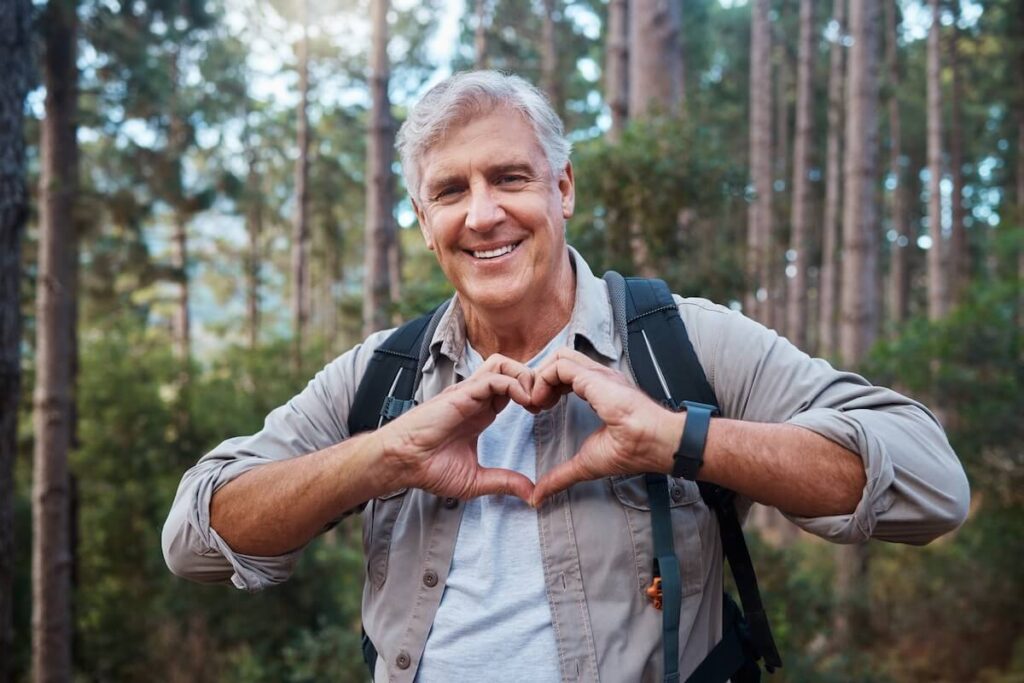 Older adult making a heart sign with his hands